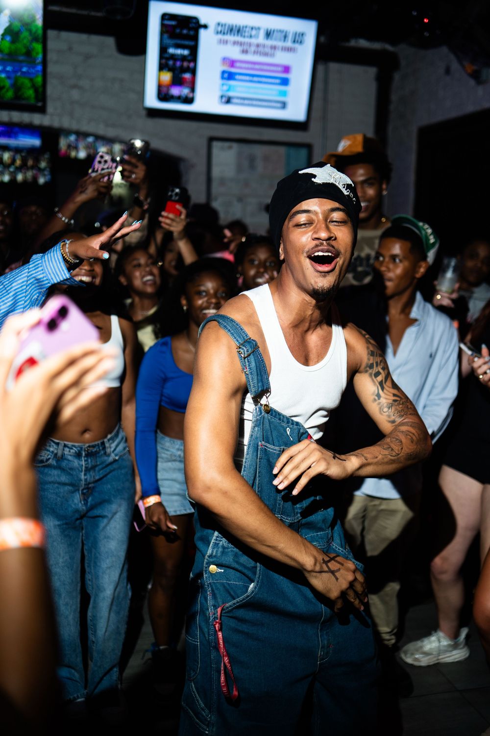 Energetic crowd dancing and enjoying themselves at an indoor nightclub venue in casual outfits and denim.