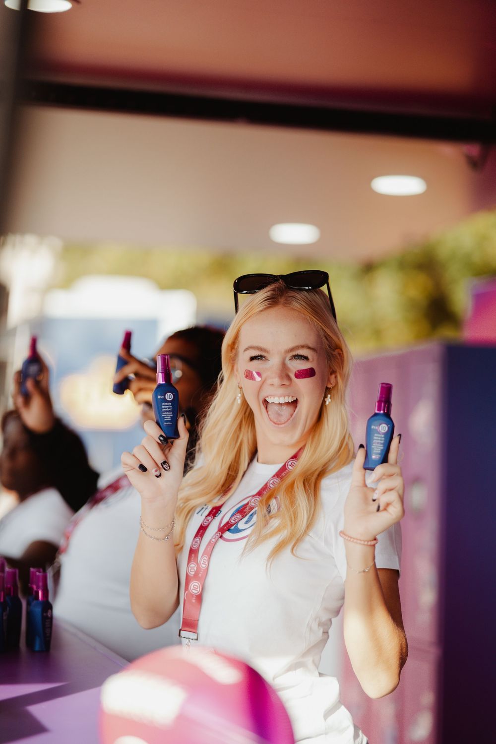 A group of people having fun at a party holding up colorful bottles and drinks in a celebratory atmosphere.