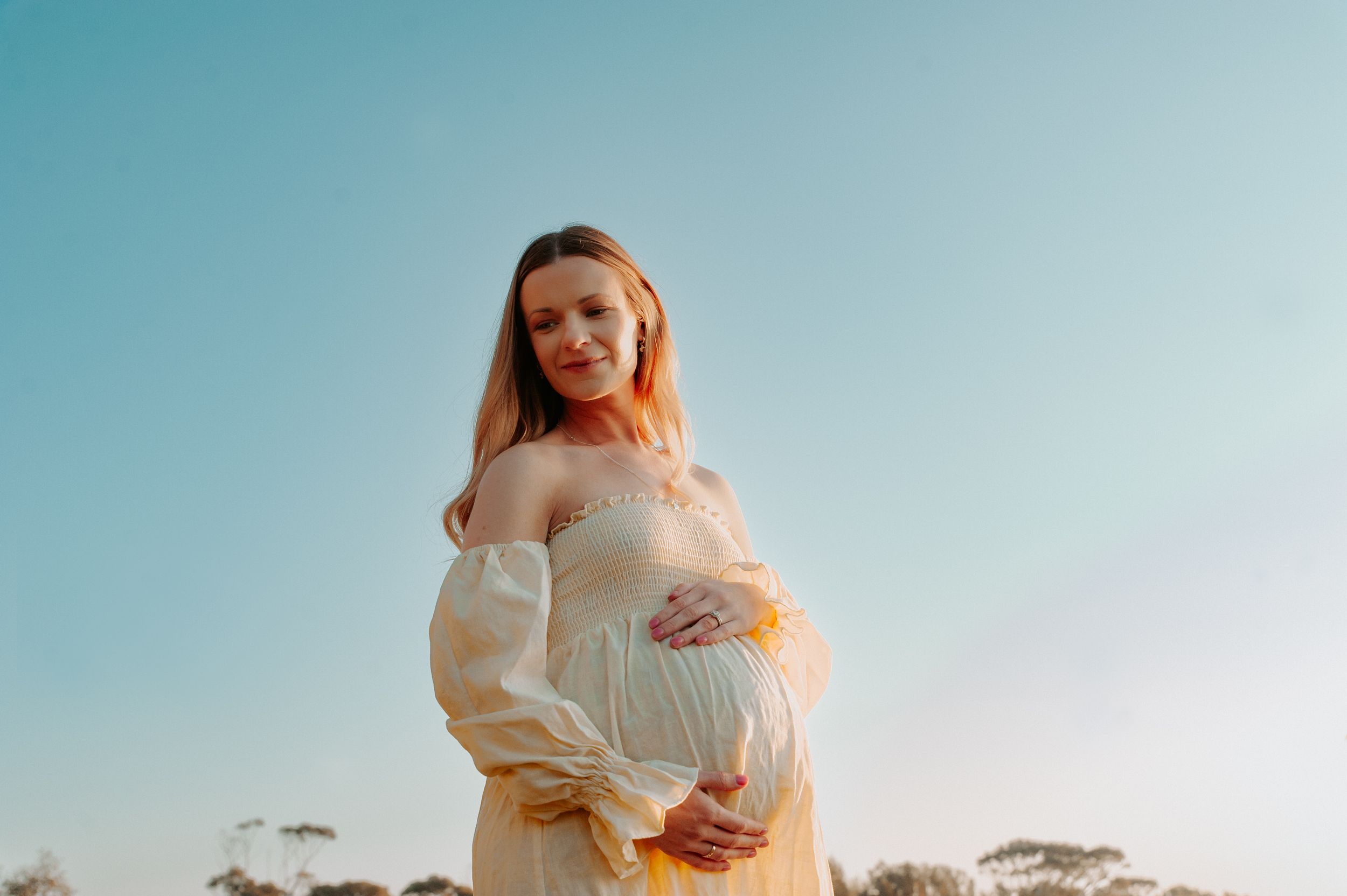 Sunset maternity portrait of woman in cream dress amid natural outdoor setting.
Altona Family Photographer Melbourne