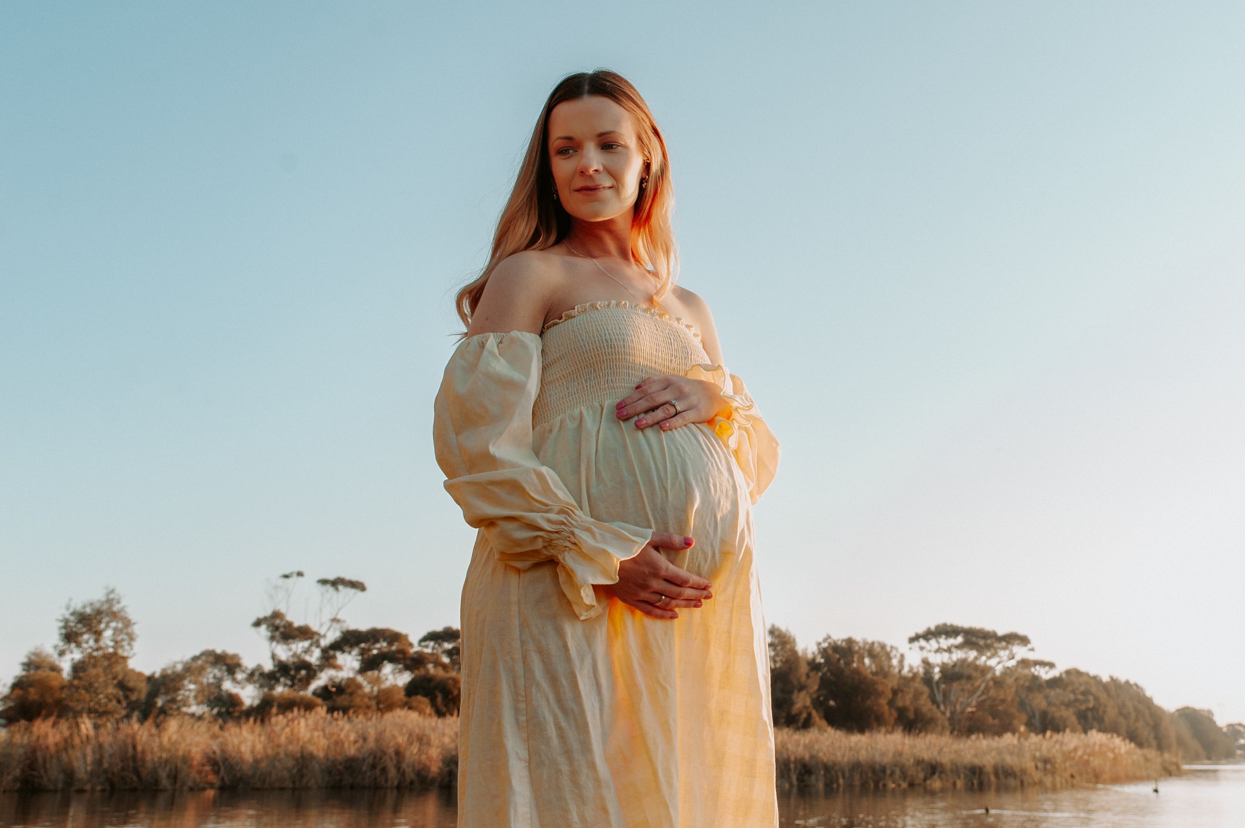 Maternity photo of woman in flowing cream dress against sunset marsh landscape.
Altona Family Photographer Melbourne