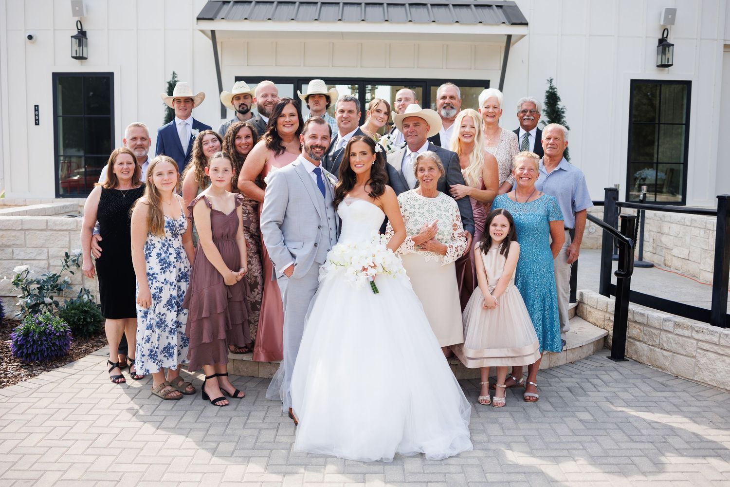Large family posing for a group wedding photo outside
