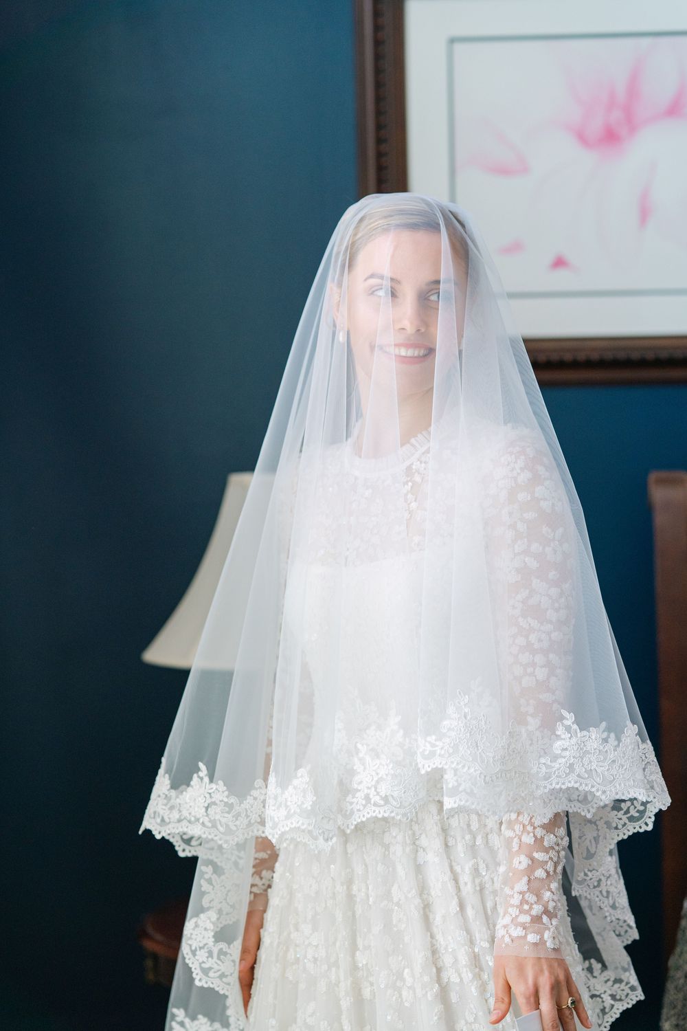 Getting Ready Portraits with a blusher veil pulled over Abby's face in her childhood home, featuring her Needle & Thread Dress