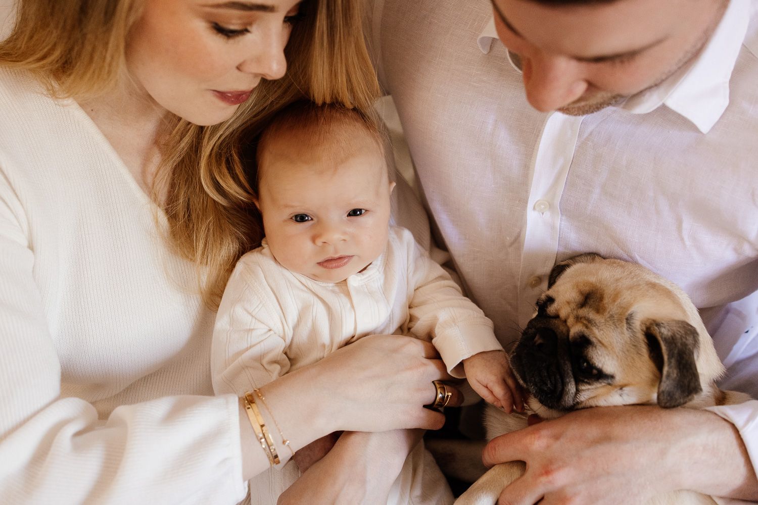 Baby and pug snuggle with their Bay Area family during their in-home photos