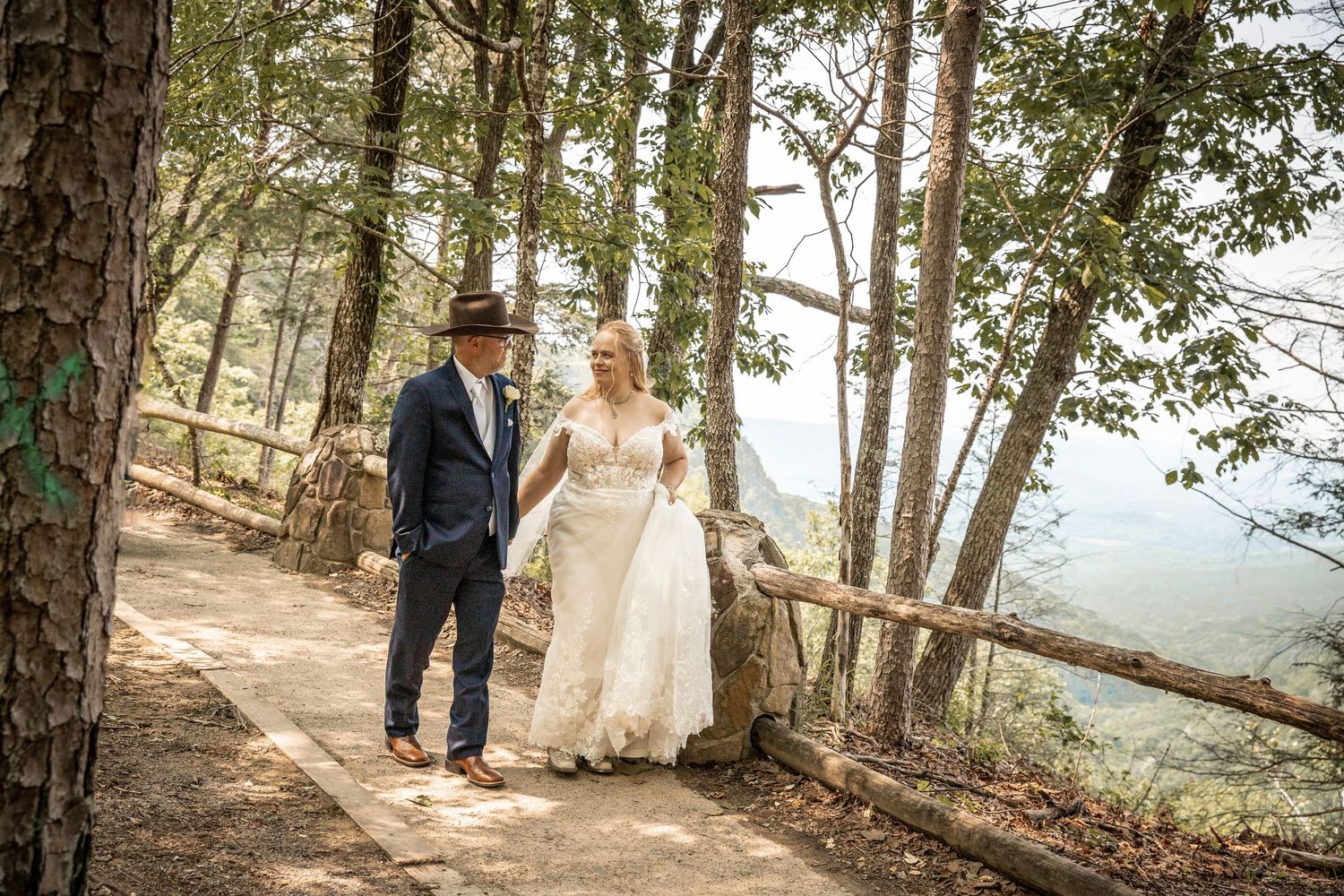 newly weds have their wedding photographer capture a wedding portrait at the top of the cliff at cloudland state park in georgia