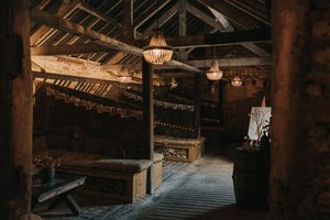 Rustic wooden beams and exposed rafters create an atmospheric interior of an old barn or warehouse space.