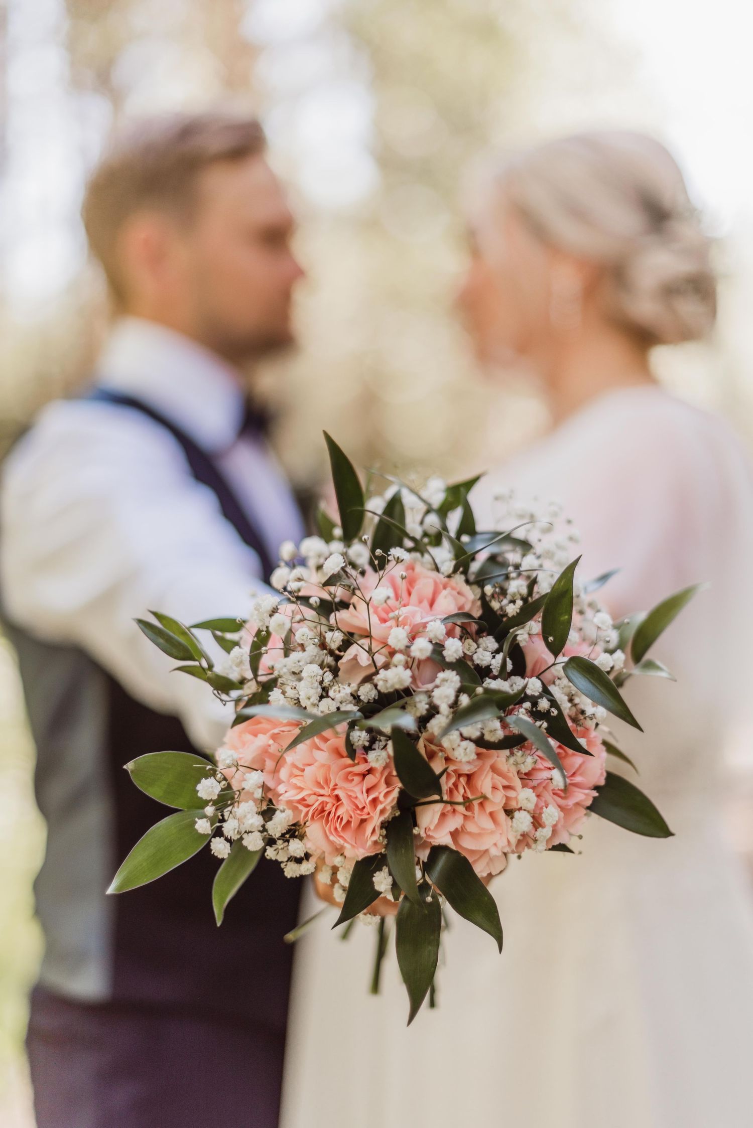 Pink and white floral arrangements with delicate greenery details for a romantic wedding celebration.