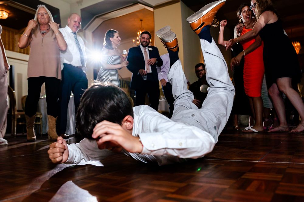 Wedding reception dance floor filled with guests doing the limbo dance.