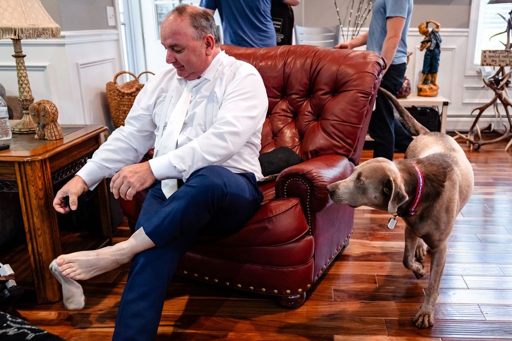 Casual gathering in living room with leather furniture and hardwood floors.