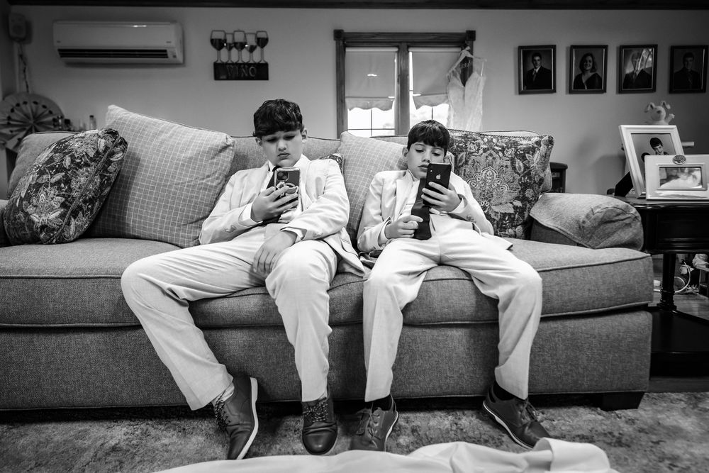 Wedding party members relaxing on a gray couch during preparation time.