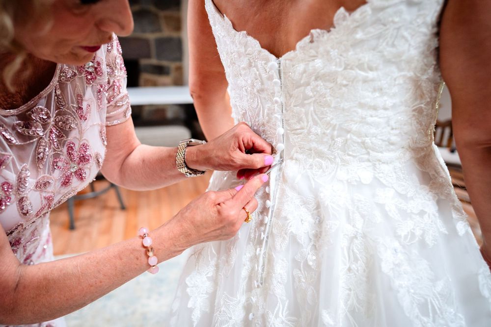 Close-up details of a white lace wedding dress with intricate beading and patterns.