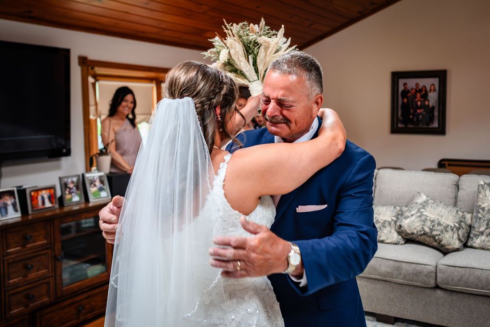 Emotional wedding moment captured in an intimate indoor setting with warm lighting.