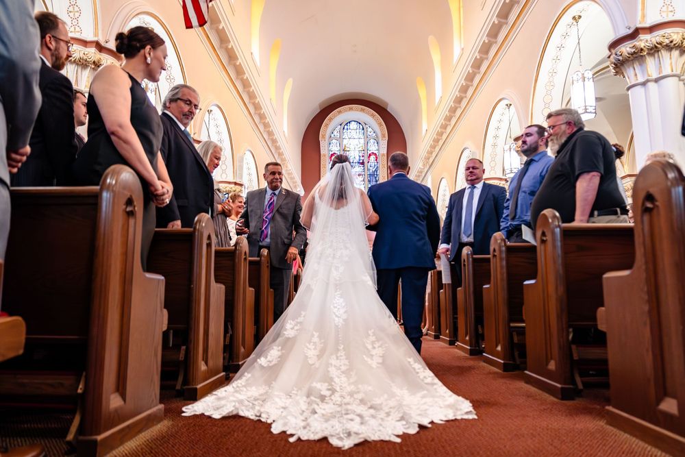 Wedding ceremony processional in ornate church with vaulted ceilings and classic architecture.