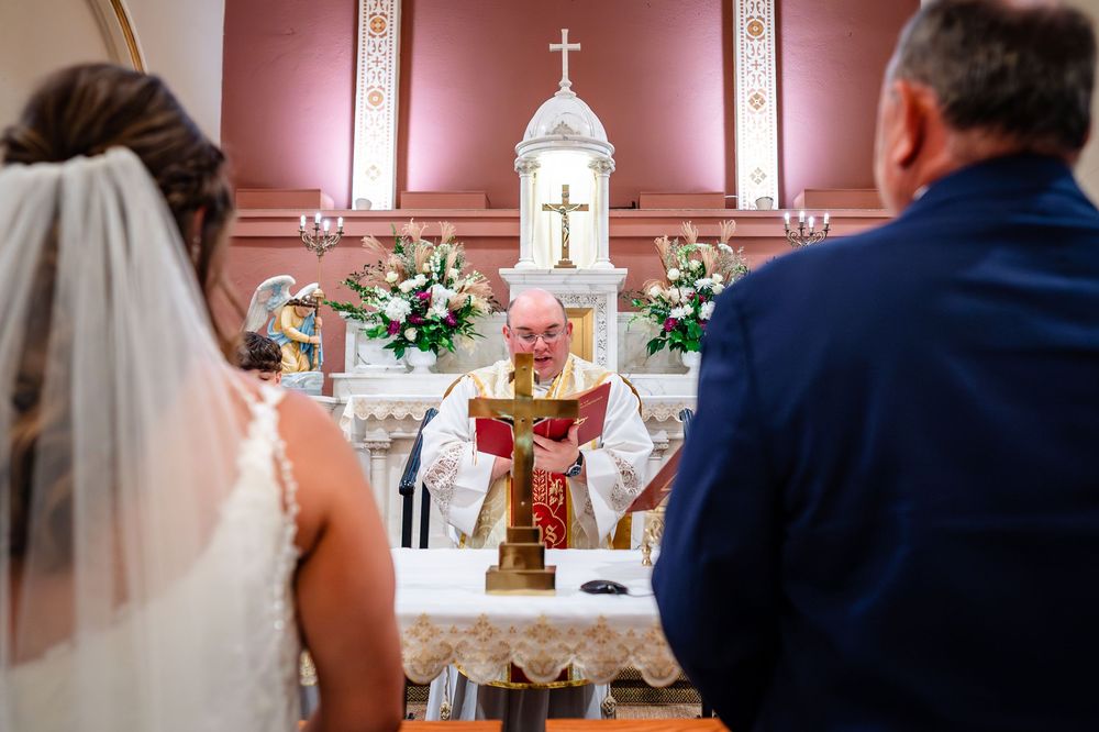 Traditional church altar decorated with flowers and crosses during a wedding ceremony.