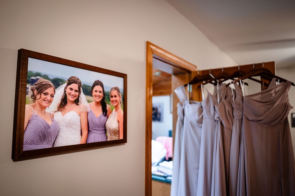 Row of light colored bridesmaid dresses hanging on display.