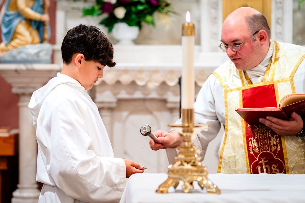 Religious ceremony with clergy and altar servers at church altar.