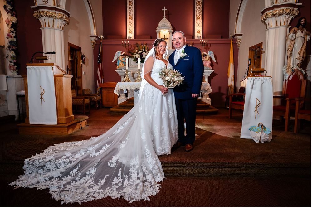 Elegant church wedding ceremony with ornate architecture and beautiful stained glass windows in the background.