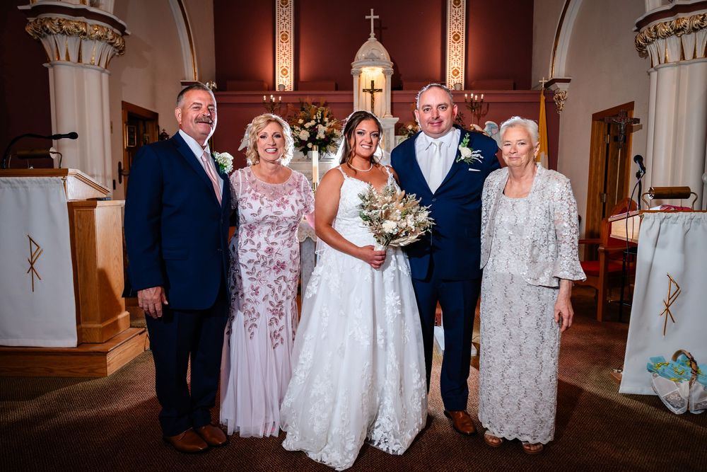Wedding party gathered inside a traditional church with arched ceilings and classical columns.