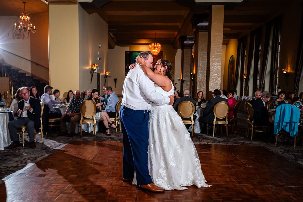 Panoramic view of wedding reception venue with couples dancing.