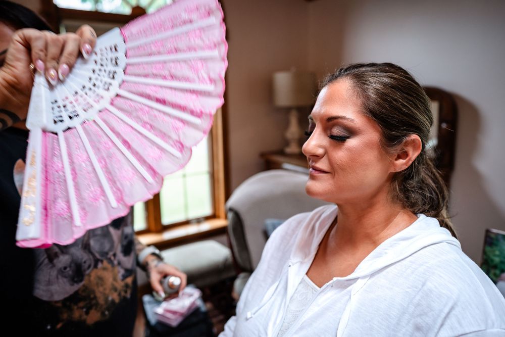 Decorative pink paper fans being displayed during wedding preparations.