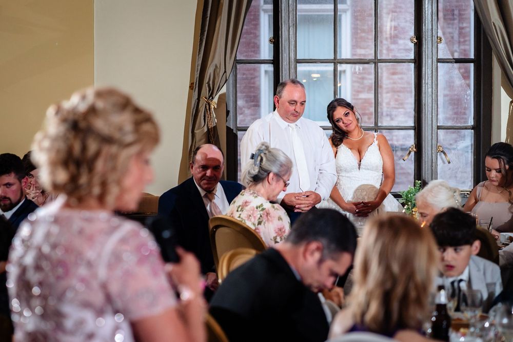 Wedding guests seated at tables during reception celebration.