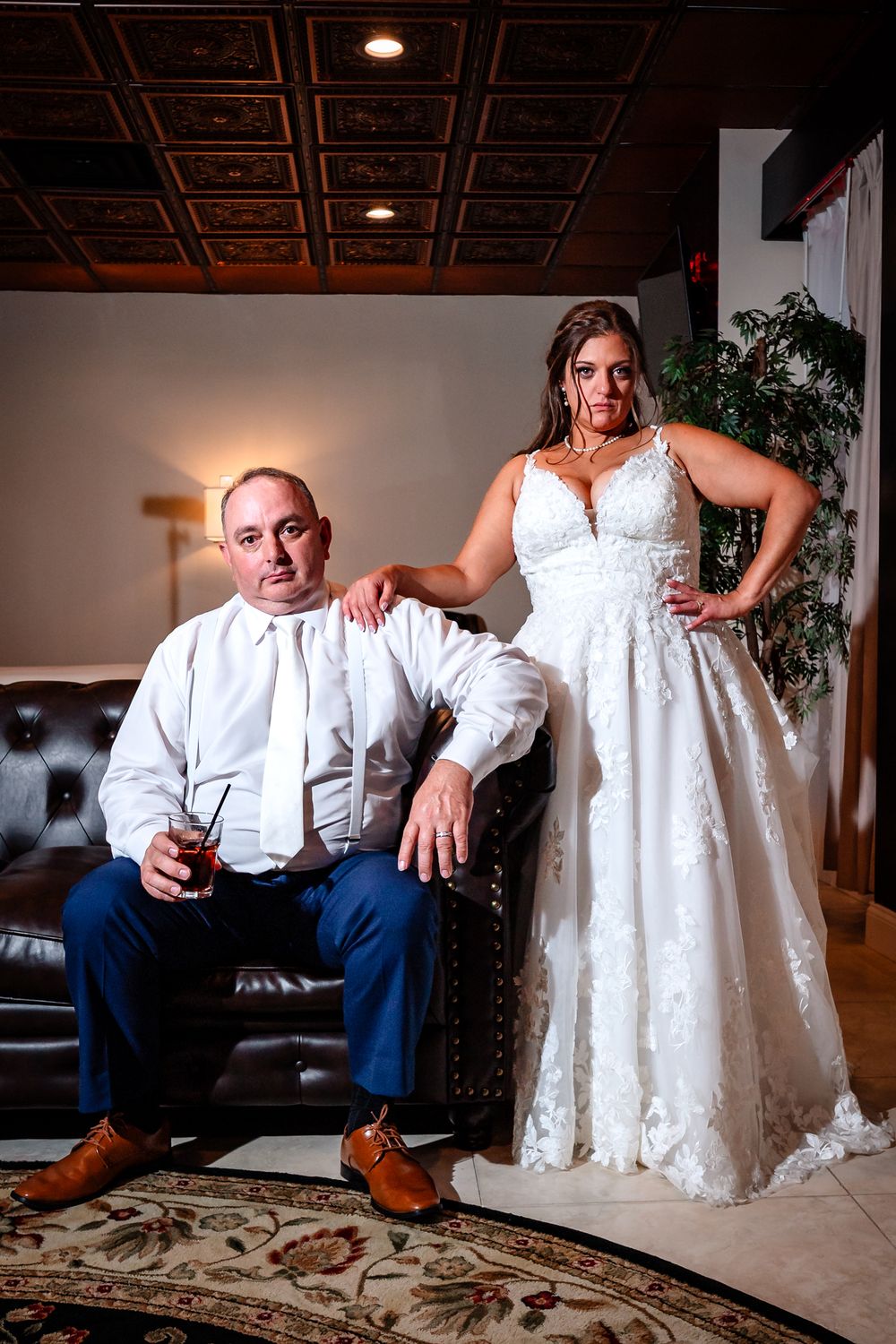 Artistic wedding portraits in elegant indoor setting with ornate ceiling.
