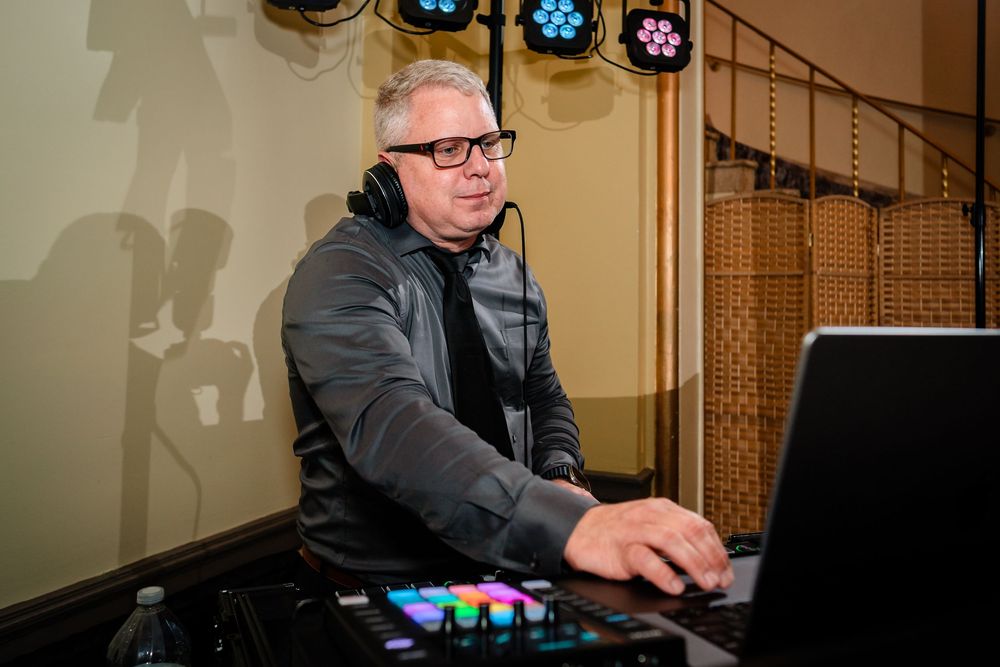 DJ booth setup with colorful lighting controls at a wedding reception.