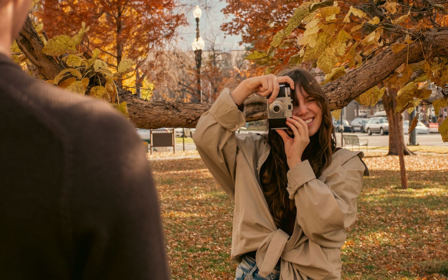 Girl takes photo of her boyfriend with vintage camera in a cinematic moment.