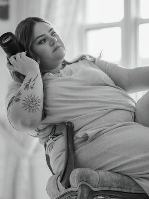 Black and white photo series showing a person in a white sweater posing artistically against a bright window backdrop.