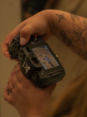 A close-up sequence showing hands rotating and examining a black camera from different angles.