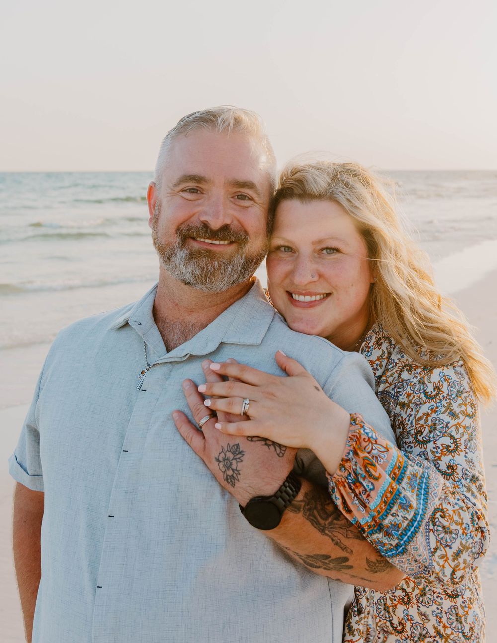 A romantic beach photoshoot at sunset with soft golden lighting and ocean backdrop.
