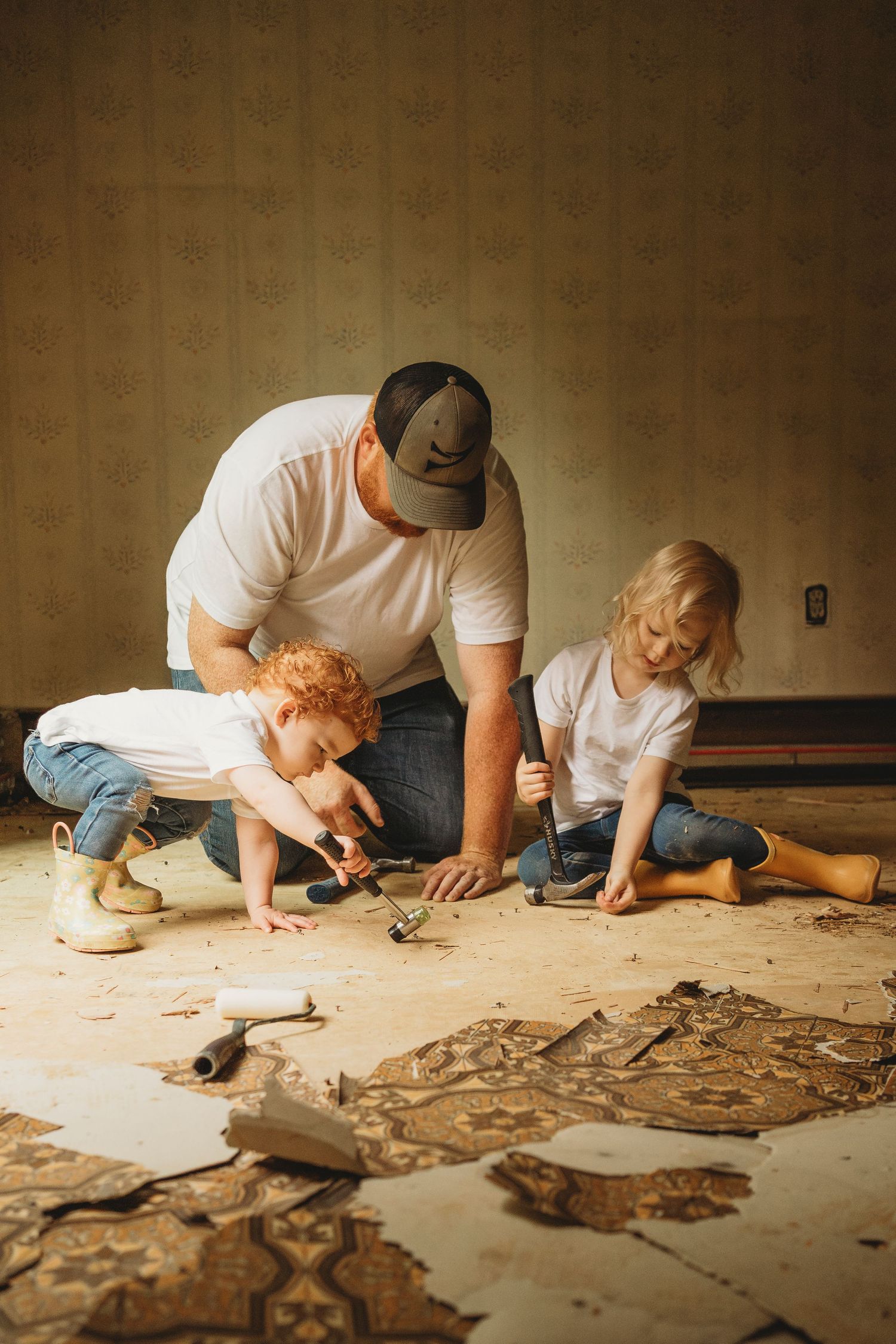Group working together on home renovation project removing old flooring.
