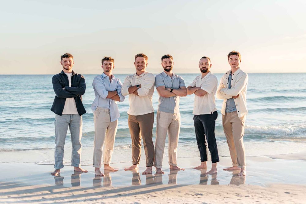 Bothers posing for photographer in a manly way with gorgeous blue ocean during sunset