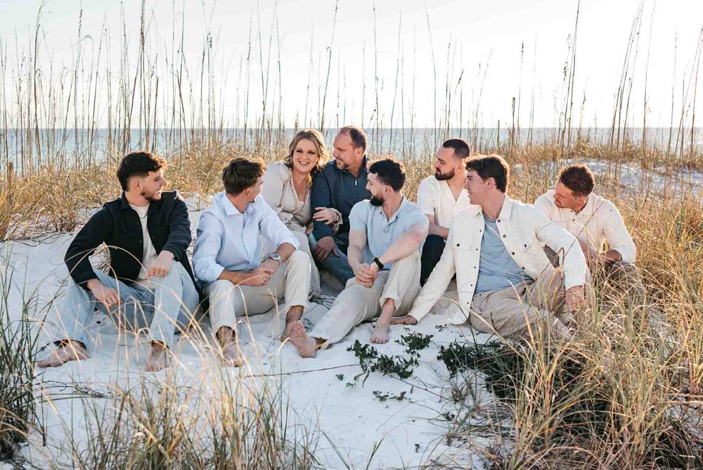 Mother and Father Family photo with their 6 sons enjoying the natural beauty of the emerald coast beaches during sunset time framed by beach