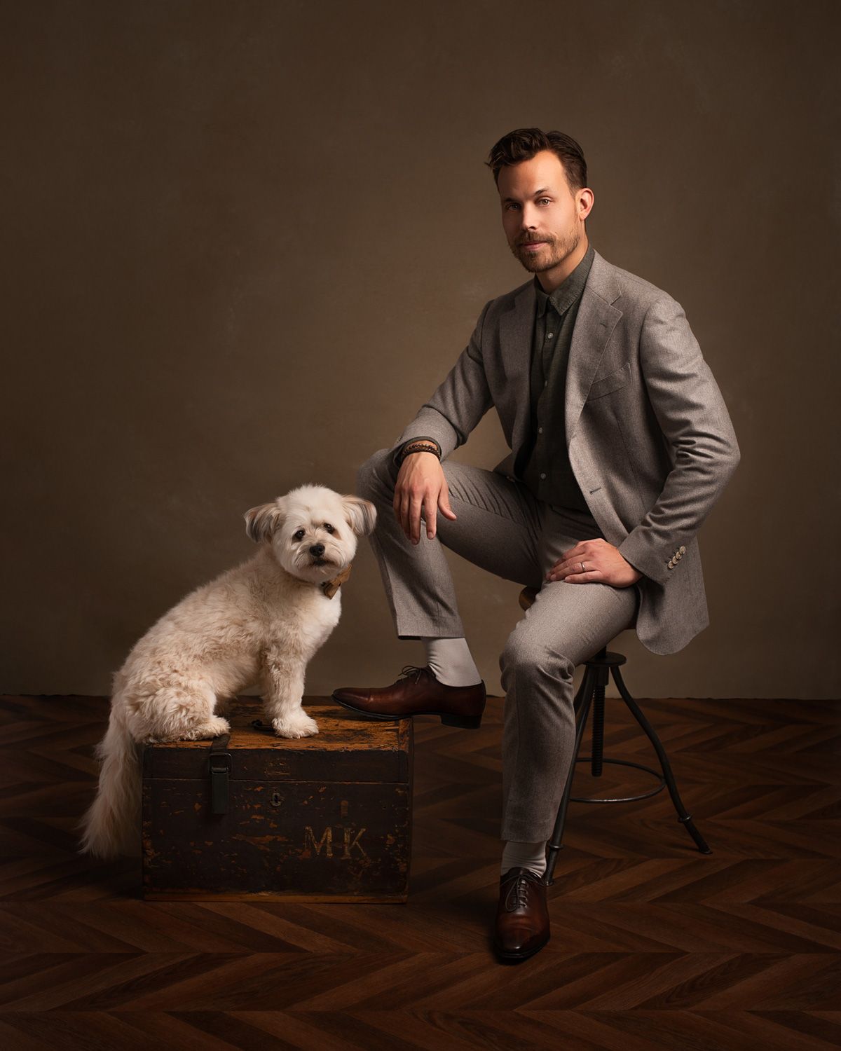 Verfijnd portret van een beeldhouwer en zijn hond, met unieke belichting die zijn artistieke visie en persoonlijkheid vastlegt.