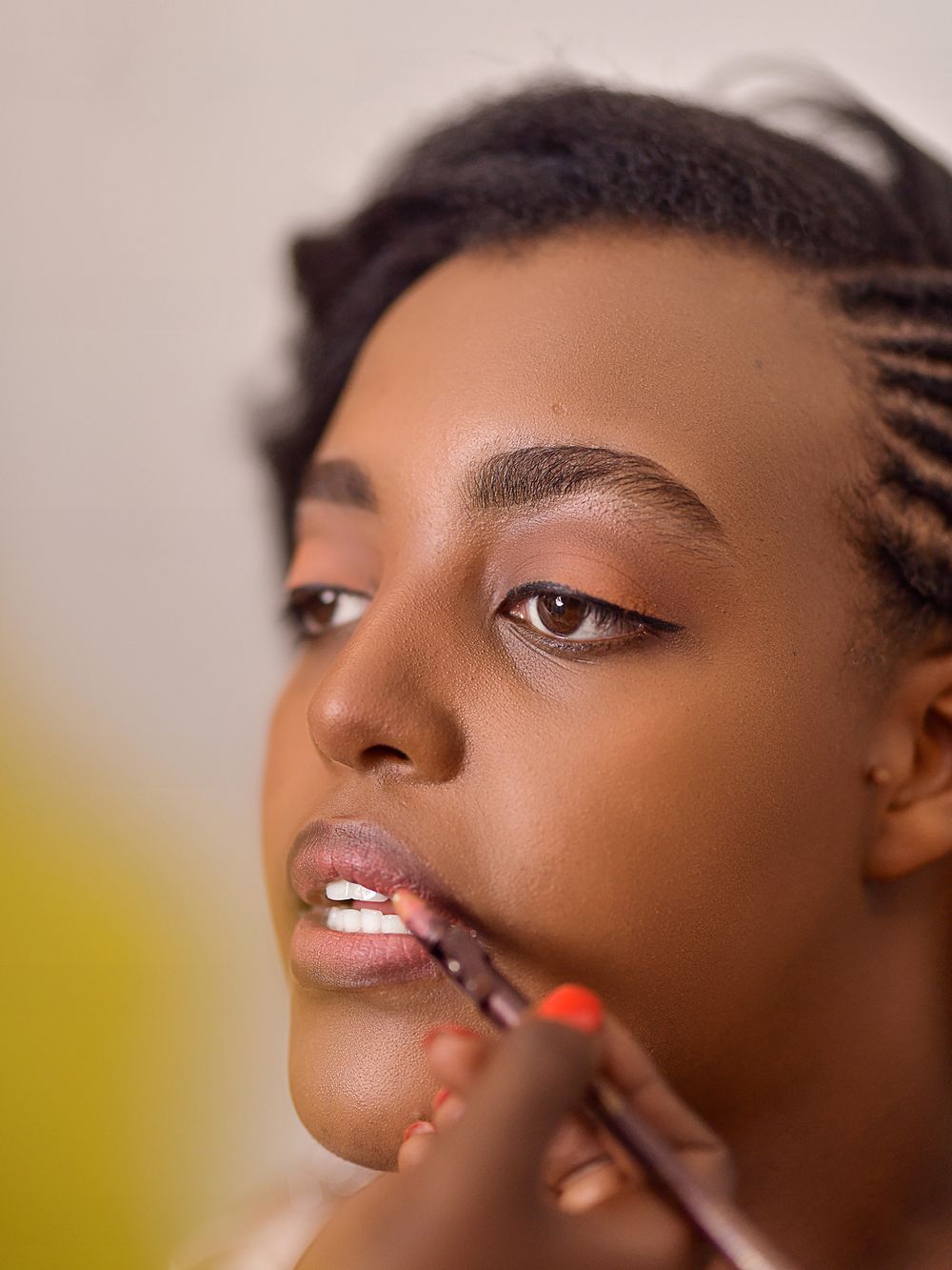 Close up shot of makeup application on lips during beauty preparation.