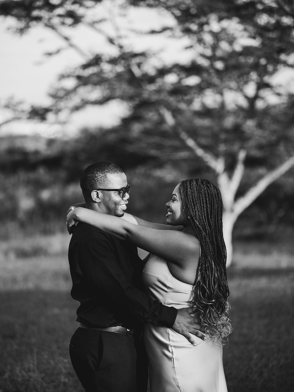Romantic black and white portrait of couple embracing outdoors.