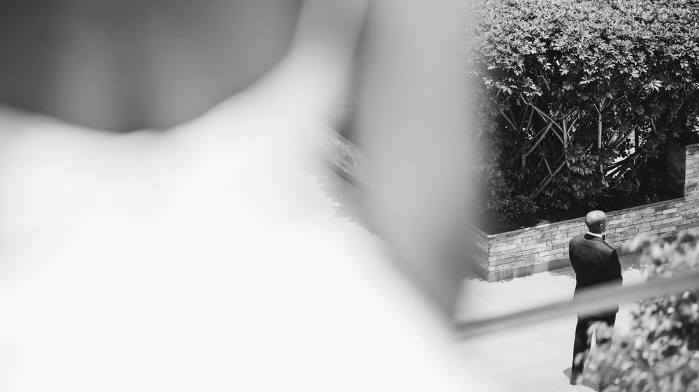 An artistic black and white photo showing a blurred white dress in the foreground.