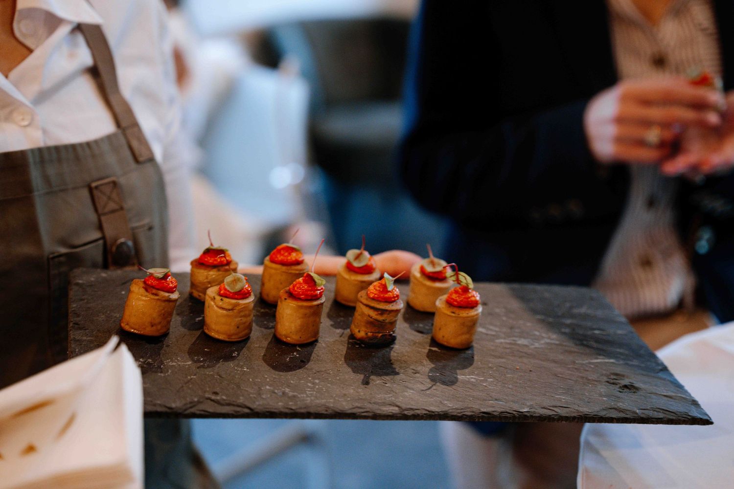 Elegant canapés arranged on a dark slate serving platter.