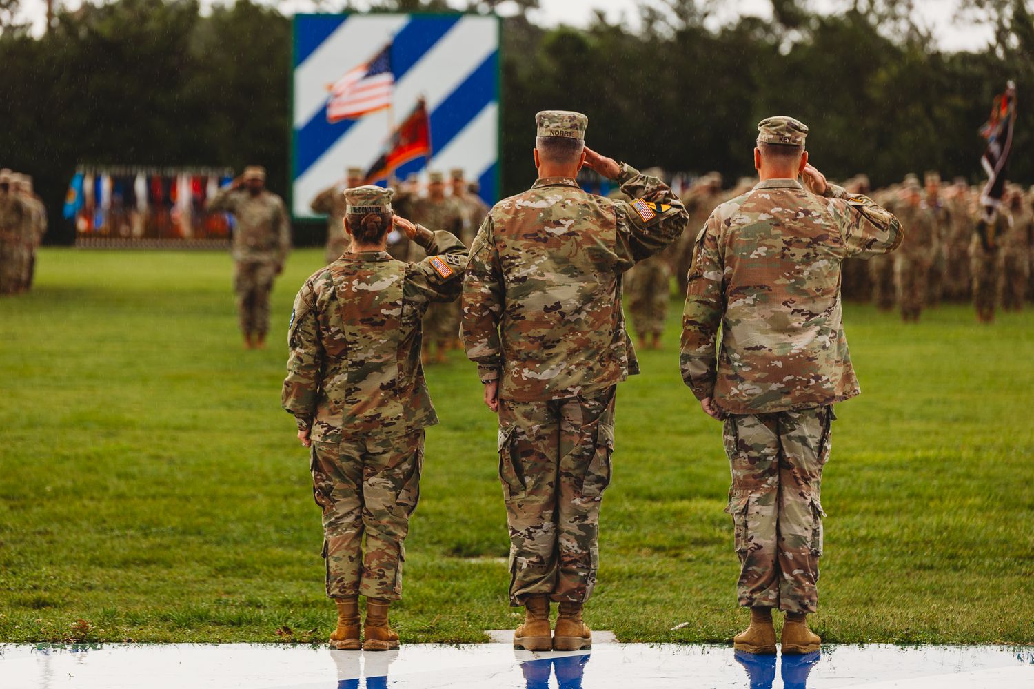 Soldiers in camouflage uniforms stand in formation on parade grounds.