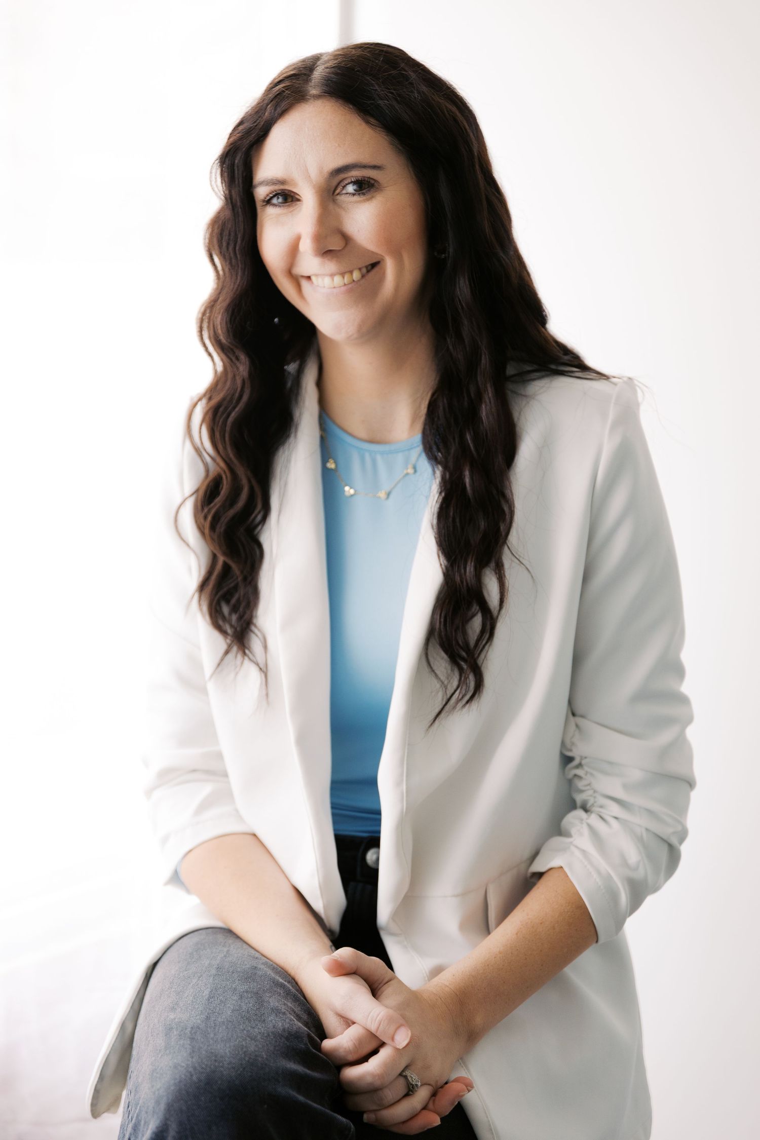 Professional headshots of woman in white blazer and blue top against white background.