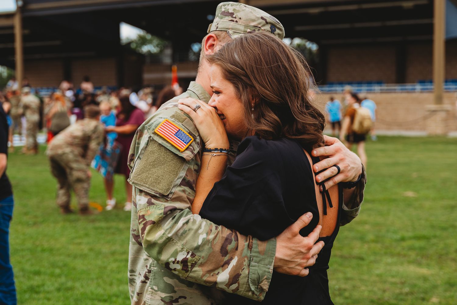 Service members and families gather at outdoor military homecoming celebration.