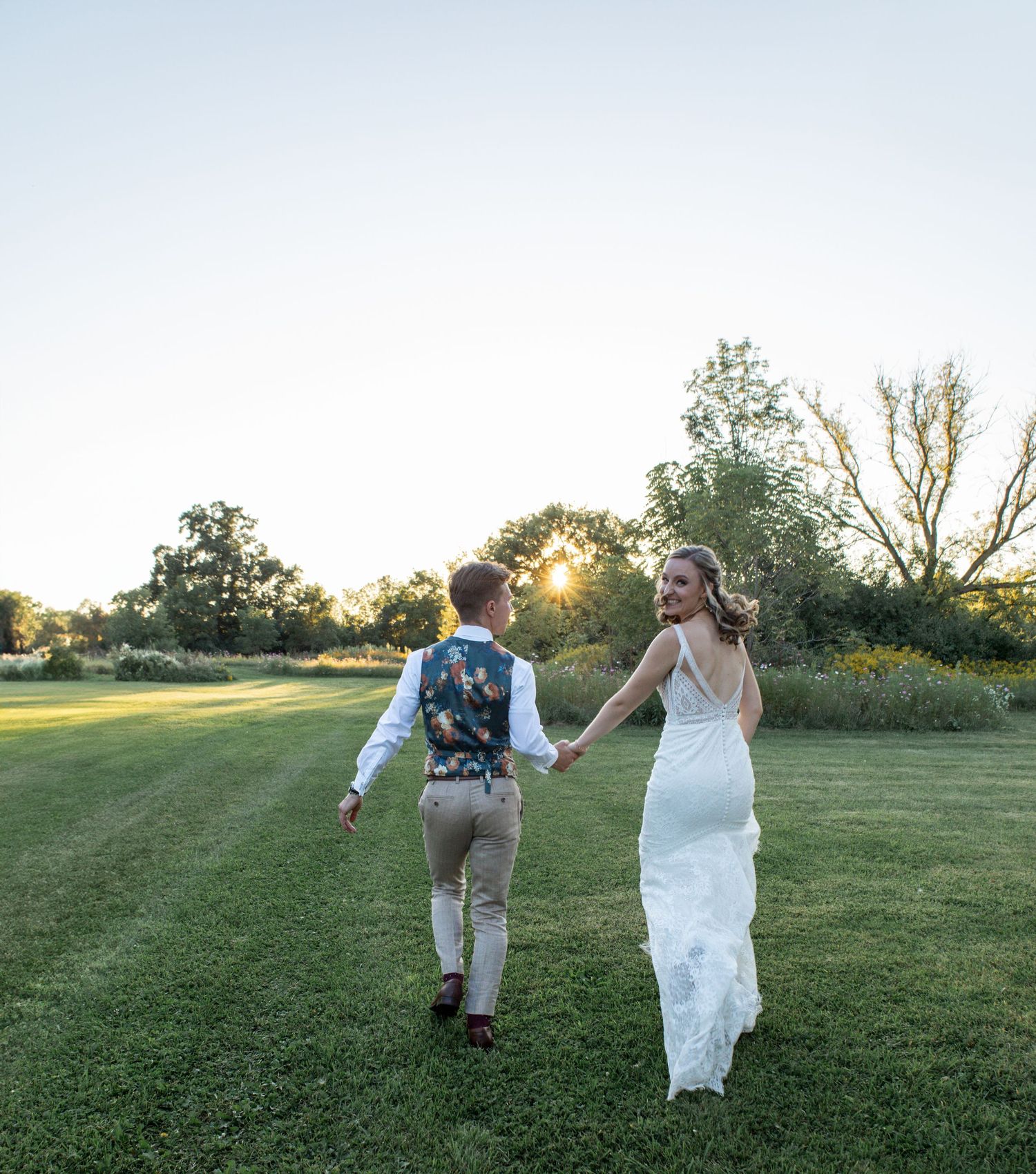 candid picture of bride and groom walking in sunset