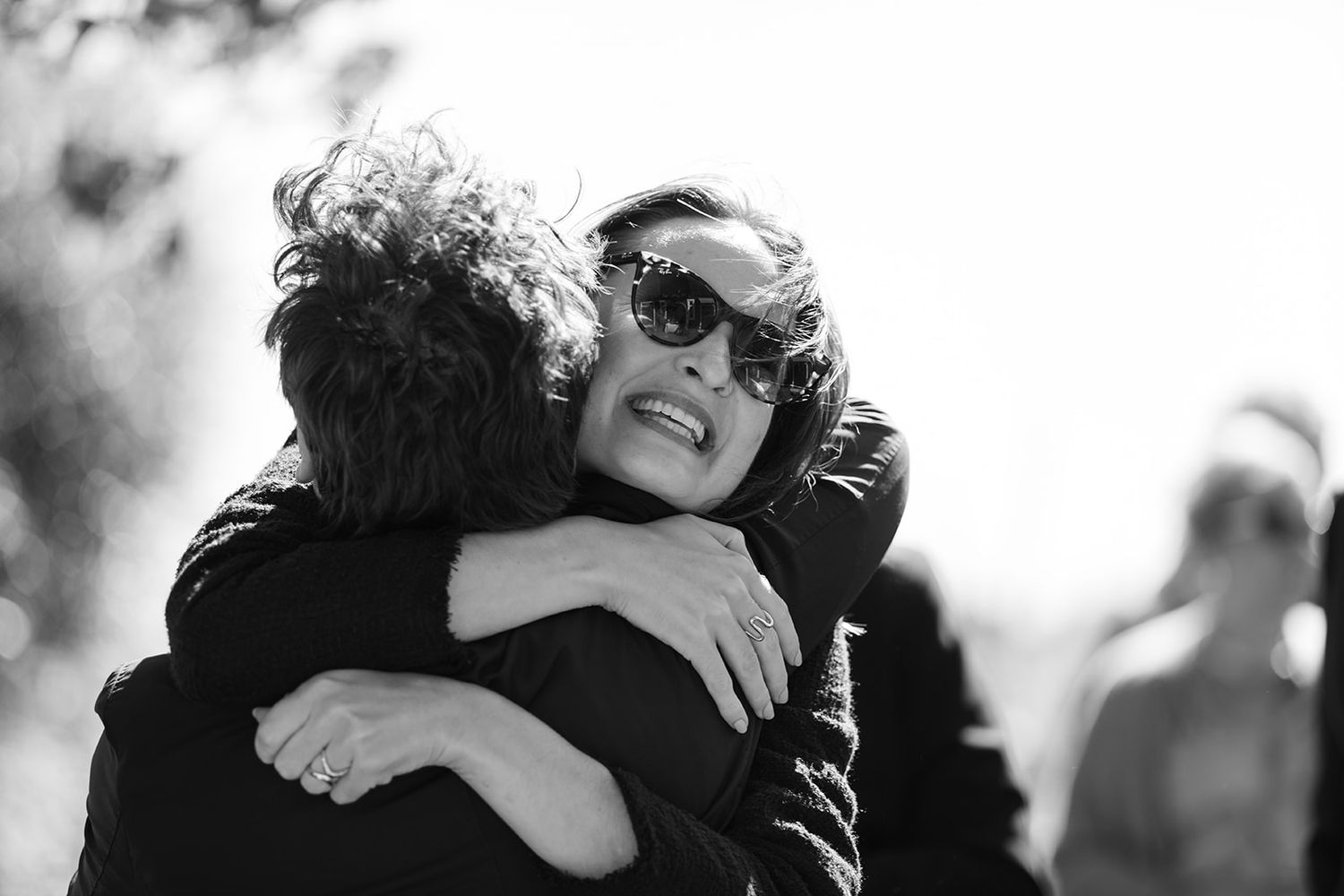 Black and white photo collage showing people embracing and hugging in various emotional moments.