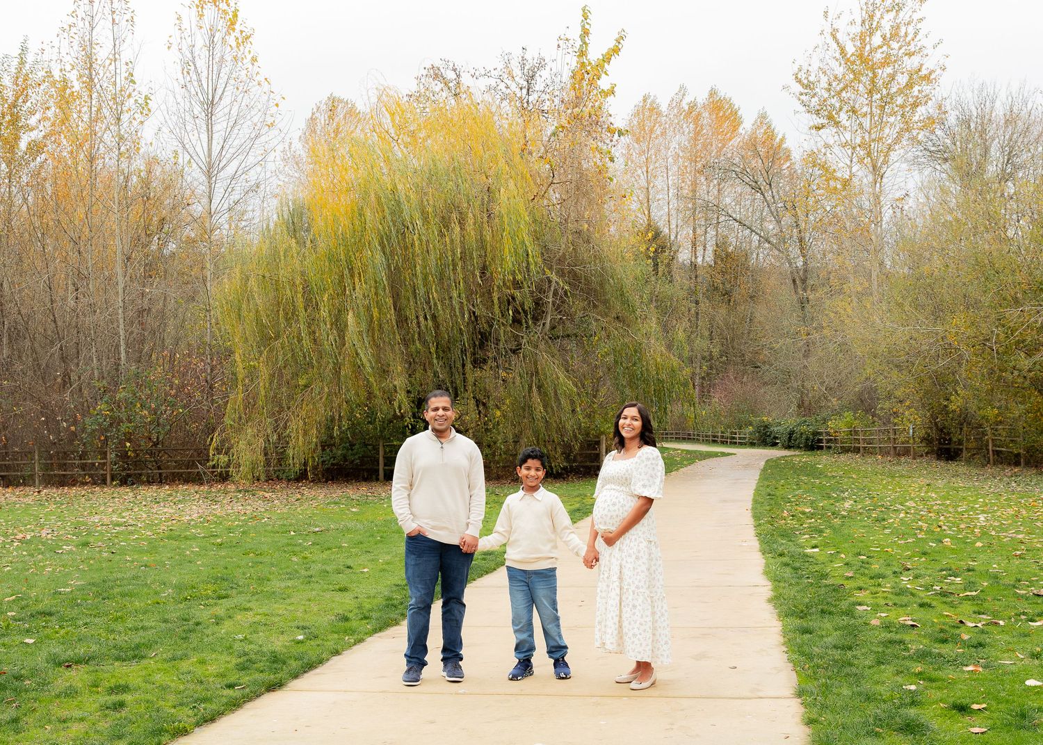 A series of outdoor photos showing people walking on a path through autumn trees and grassy fields.
