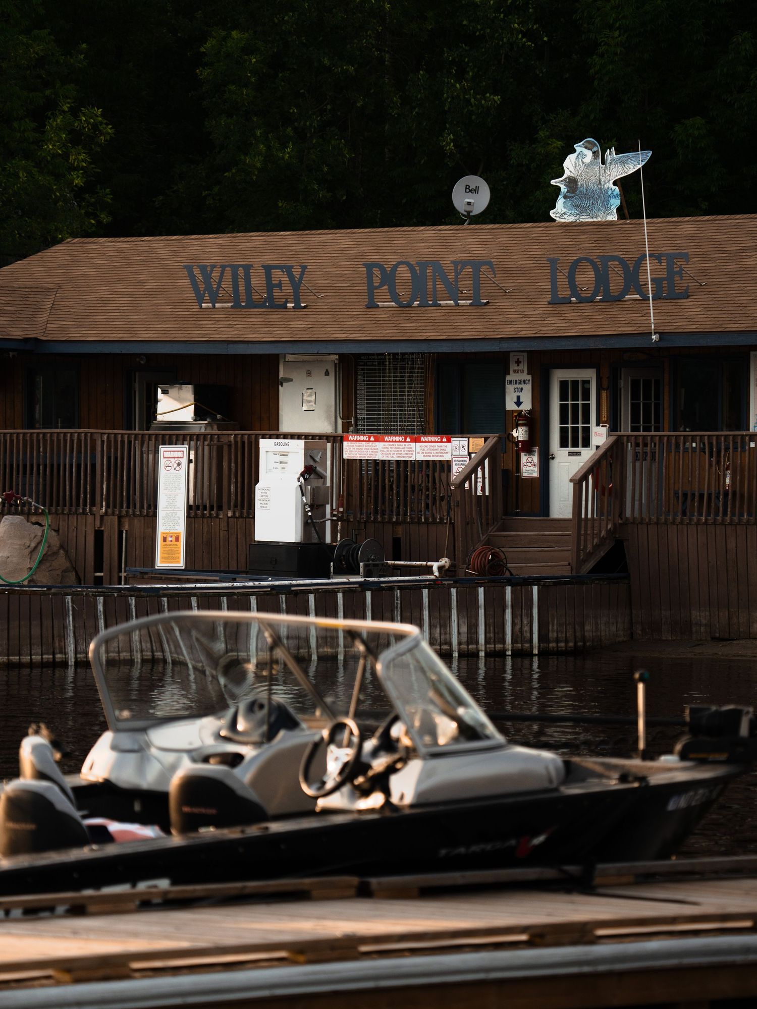 Row of rustic wooden cabins and boat docks at a lakeside resort.