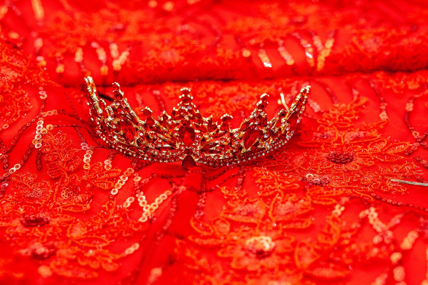 A close-up view of red chili peppers drying in the sun shows their vibrant color and wrinkled texture.