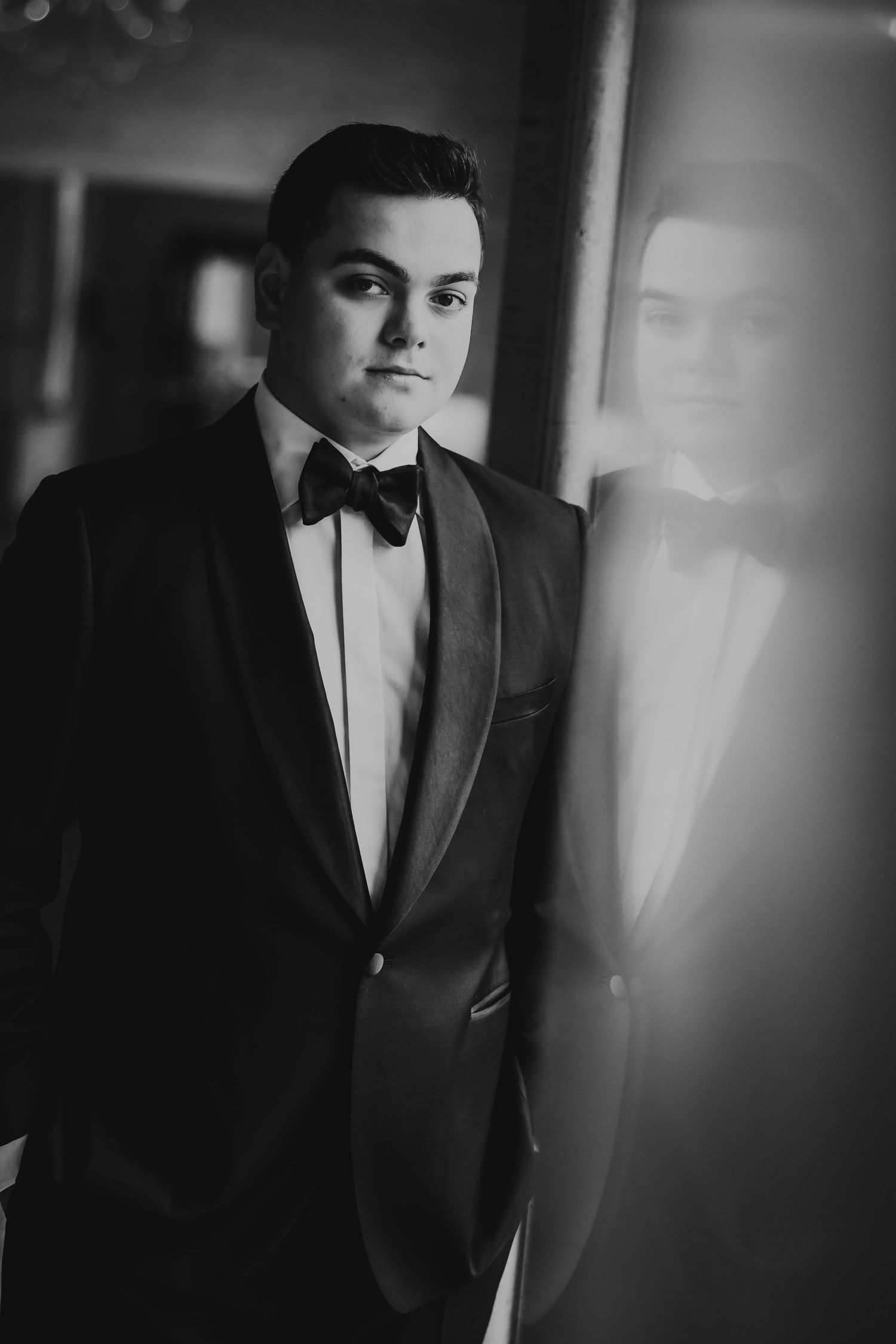 Black and white portrait series showing a person in a formal tuxedo and bowtie against a dark background.