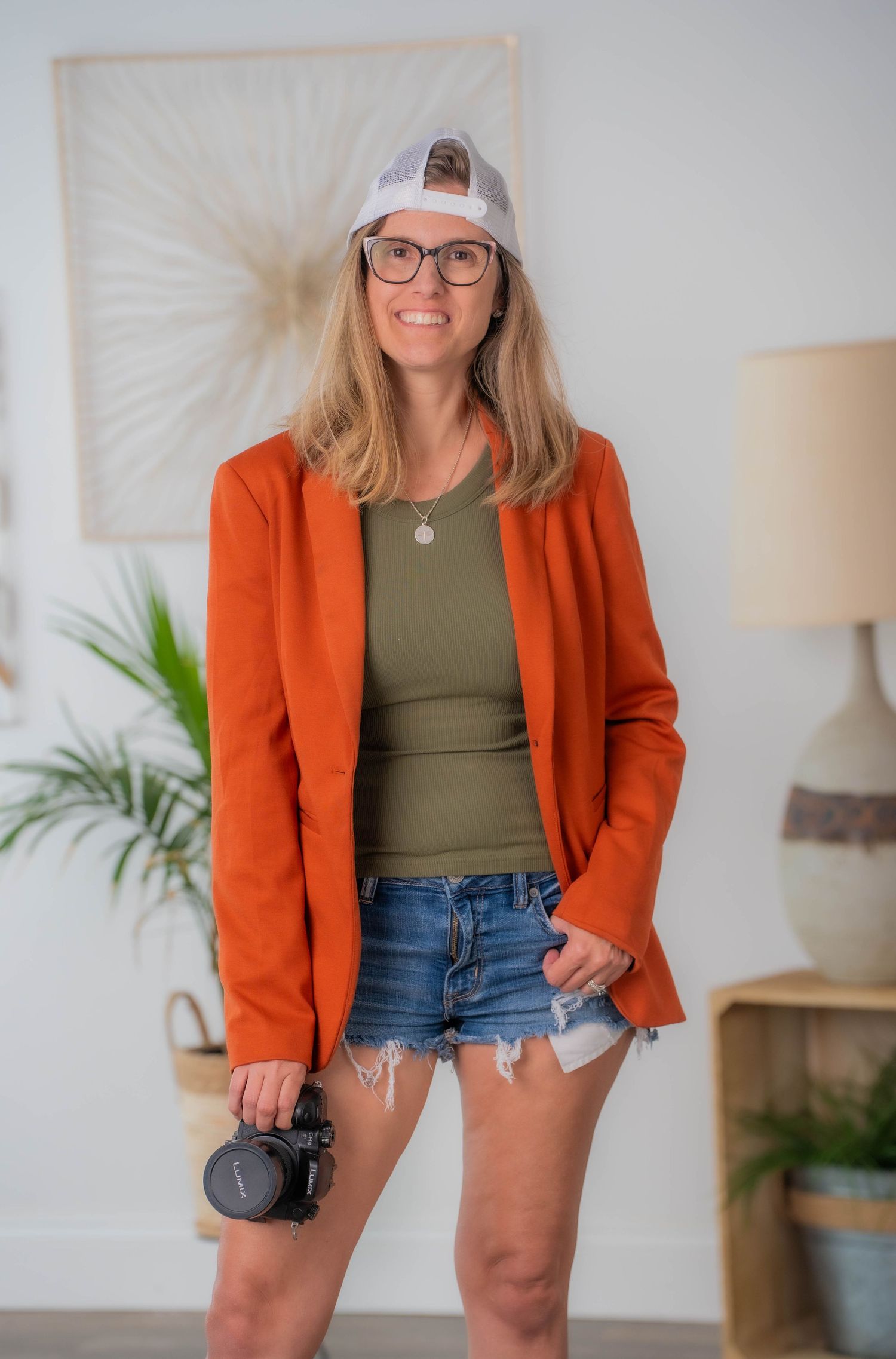 Fashion photos featuring an orange blazer styled with olive top and denim shorts.