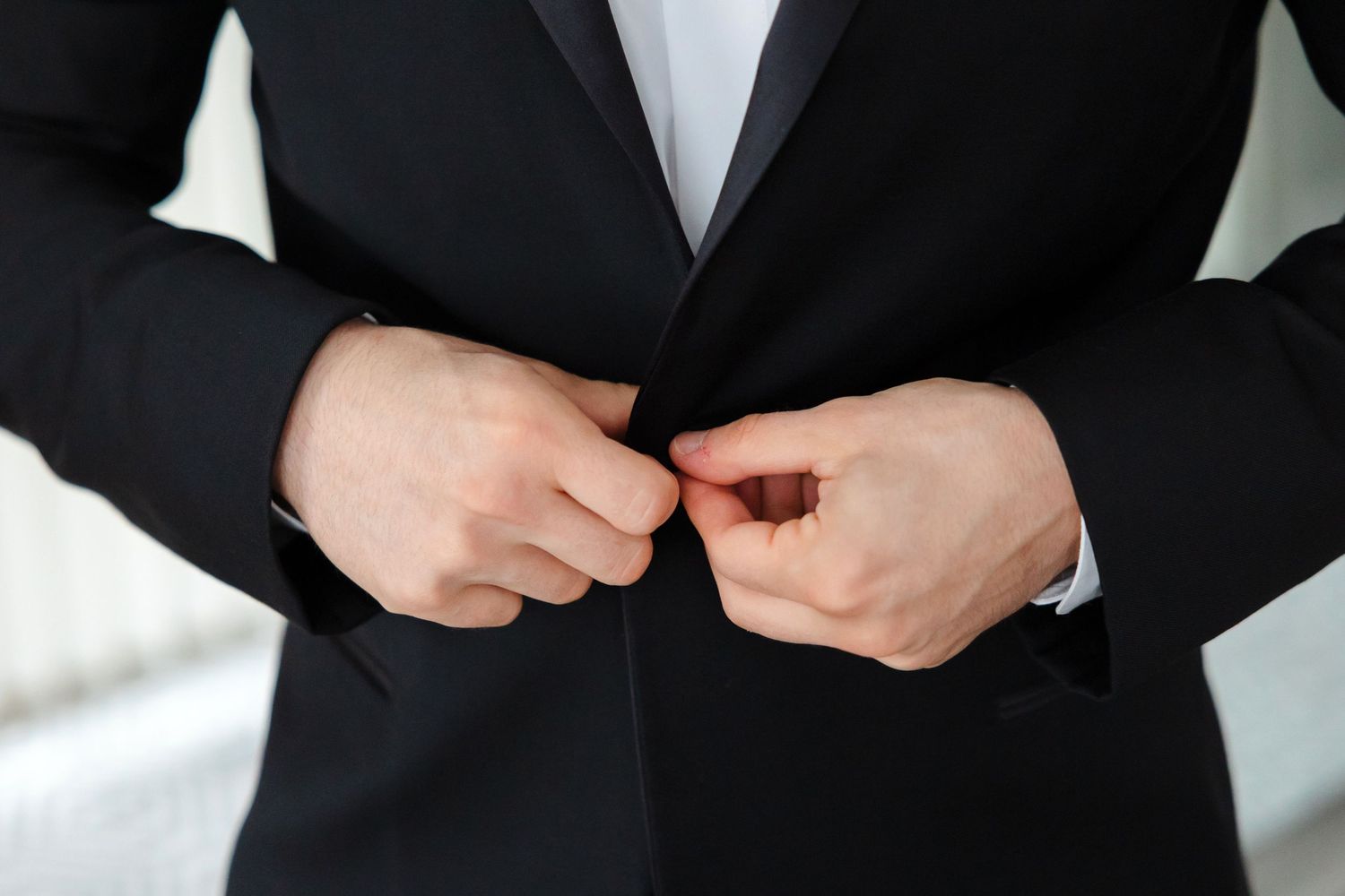 Groom buttoning suit coat photographed by Tom Forrest Photography.