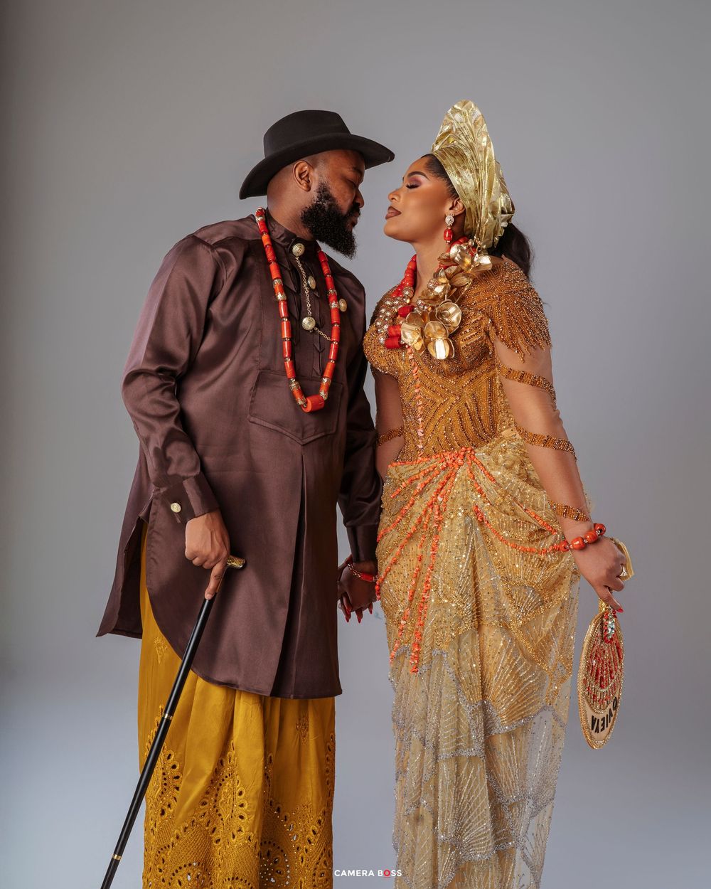 Couple in western attire, with person in brown jacket and yellow skirt alongside person in gold sequined dress posing together.